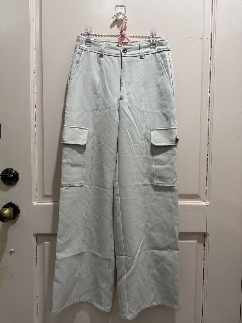 GU Cargo Pants Off-White Size S (Category: Joggers) located in Davao. Submitted by 2ndbase.dvo.ii (Listing ID 1470600655, Image 2). Description: - Brand: GU - Item: Cargo pants - Color: Off-white - Size: S - Fit: High-waisted, straight wide leg - Details: Utility pockets on both sides - Material: Polyester, rayon, and polyurethane blend - Condition: Brand new with tag still attached inside, clean, no stains.