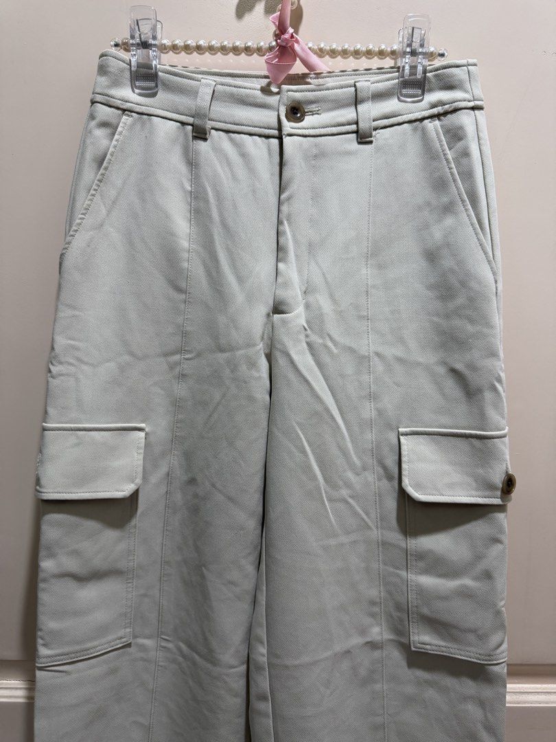 GU Cargo Pants Off-White Size S (Category: Joggers) located in Davao. Submitted by 2ndbase.dvo.ii (Listing ID 1470600655, Image 3). Description: - Brand: GU - Item: Cargo pants - Color: Off-white - Size: S - Fit: High-waisted, straight wide leg - Details: Utility pockets on both sides - Material: Polyester, rayon, and polyurethane blend - Condition: Brand new with tag still attached inside, clean, no stains.