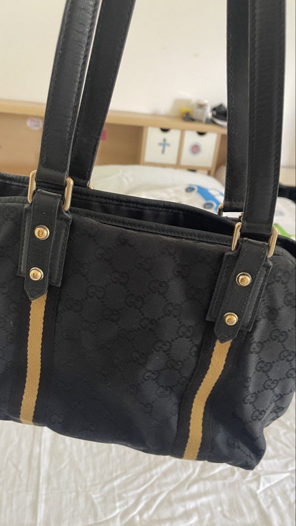 Gucci Black GG Monogram Canvas Tote Bag (Category: Luxury Bags & Wallets) located in Rizal. Submitted by annelimited_stuffs (Listing ID 1470670375, Image 2). Description: - Authentic Gucci tote bag in black GG monogram canvas - Features iconic yellow and black web stripe accents - Premium black leather double top handles and gold-tone hardware - Spacious interior compartment for everyday essentials - Condition: Minor wear on bottom corner stitchi