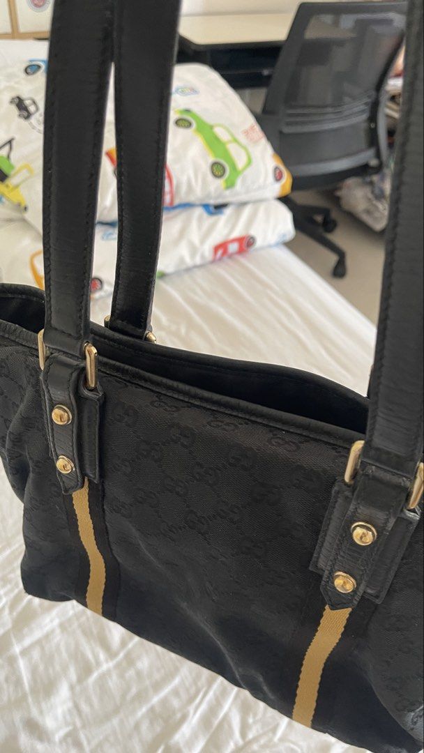 Gucci Black GG Monogram Canvas Tote Bag (Category: Luxury Bags & Wallets) located in Rizal. Submitted by annelimited_stuffs (Listing ID 1470670375, Image 3). Description: - Authentic Gucci tote bag in black GG monogram canvas - Features iconic yellow and black web stripe accents - Premium black leather double top handles and gold-tone hardware - Spacious interior compartment for everyday essentials - Condition: Minor wear on bottom corner stitchi