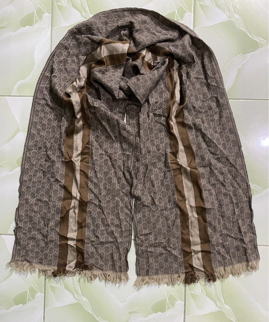 Gucci GG Monogram Wool Silk Scarf Brown (Category: Scarves) located in Pozorrubio. Submitted by izaykite2g (Listing ID 1470682941, Image 1). Description: - Authentic classic Gucci monogram scarf in brown and cream tones - 14 inches x 69 inches - Features the iconic GG pattern with stylish striped borders and fringed edges - Luxurious 80% wool and 20% silk blend for warmth and comfort - Dry clean only - Perfect accessory for cooler weather.