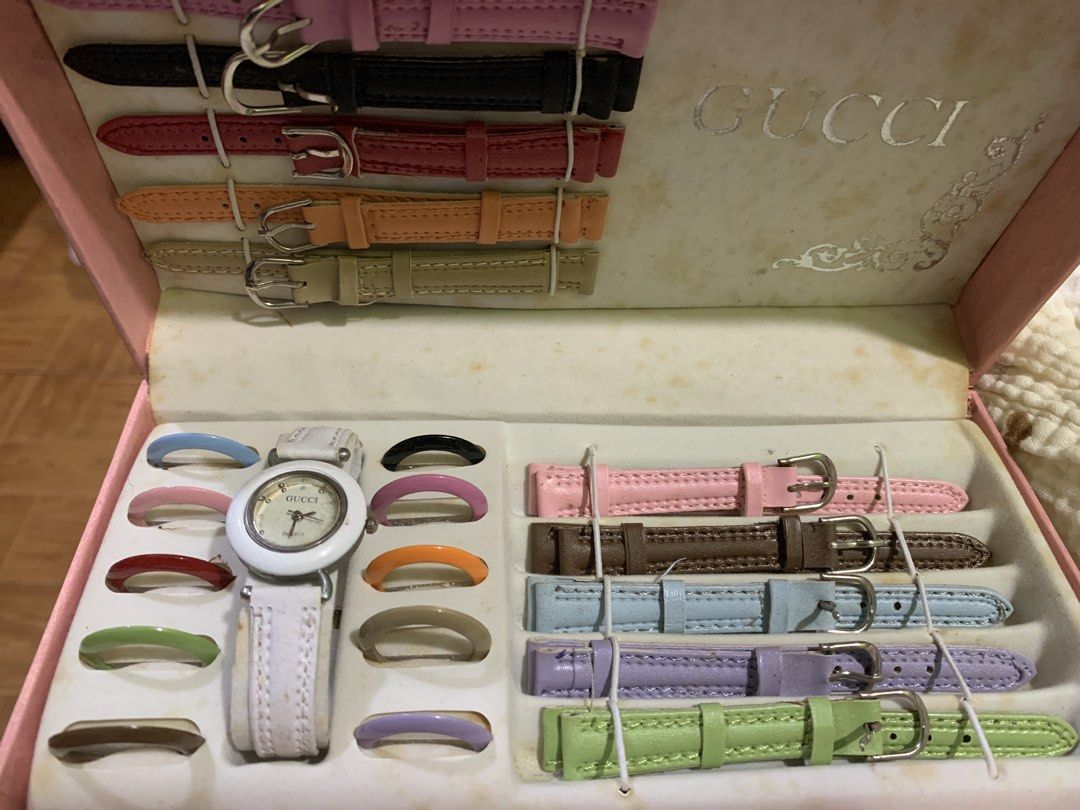 Gucci Interchangeable Bezel Watch Set with Extra Straps (Category: Women's Watches) located in Antipolo. Submitted by cebb888 (Listing ID 1470650592, Image 2). Description: - Brand: Gucci - Set Includes: 1 white bezel watch body, 10 colorful interchangeable bezel rings, and 10 leather straps - Strap Colors: Pink, black, red, orange, beige, brown, blue, purple, green, and more - Hardware: Gold-tone buckles and strap loops - Packaging: Original pin