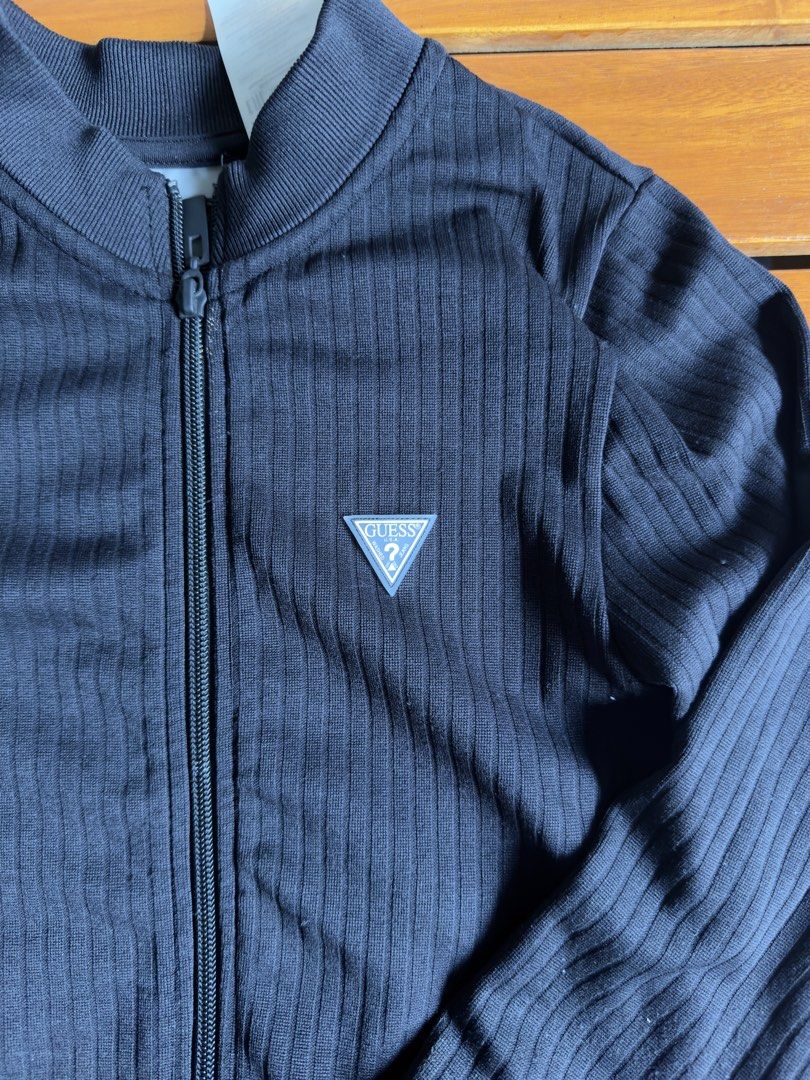Guess Black Ribbed Zip-Up Jacket xs/s (Category: Coats, Jackets and Outerwear) located in Tuguegarao City. Submitted by joysmithznjo (Listing ID 1470615639, Image 2). Description: - Brand: Guess - Size: XS/S - Color: Black - Condition: Brand new with tag still attached - Material: 94% polyamide, 6% spandex (stretchy & comfortable) - Features: All-over ribbed knit texture, full front zipper, classic Guess triangle logo patch on chest, ribbed colla