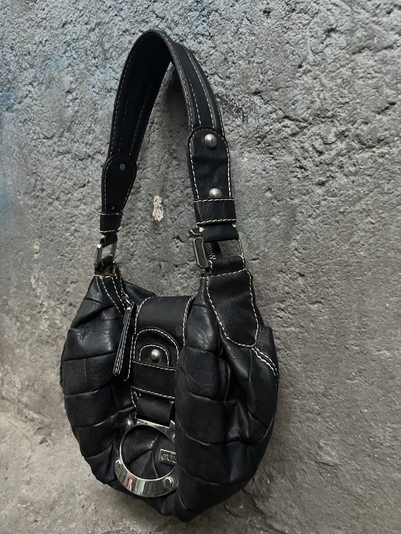 Guess Black Shoulder Bag with Large G Logo (Category: Shoulder Bags) located in Muntinlupa City. Submitted by cutiepie143 (Listing ID 1470715908, Image 2). Description: - Brand: Guess - Color: Black with contrast white topstitching - Material: Faux leather - Design: Distinctive large silver-tone G logo buckle and quilted side panels - Hardware: Metal studs on the single shoulder strap - Closure & Storage: Secure zip top closure with an interior z