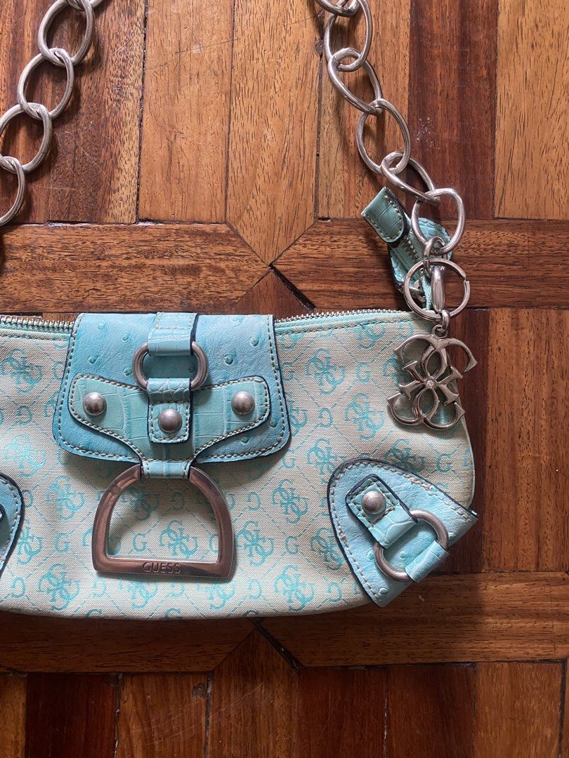 Guess Blue Monogram Shoulder Bag Chain Strap (Category: Shoulder Bags) located in Manila. Submitted by anthony1723 (Listing ID 1470697107, Image 2). Description: - Brand: Guess - Style: Y2K aqua blue monogram shoulder bag - Details: Faux ostrich leather trim, silver hardware, chunky chain strap, and dangling G logo charm - Closure: Magnetic snap flap with main zippered compartment - Interior: One zipper pocket and two slip pockets - Condition: Sh