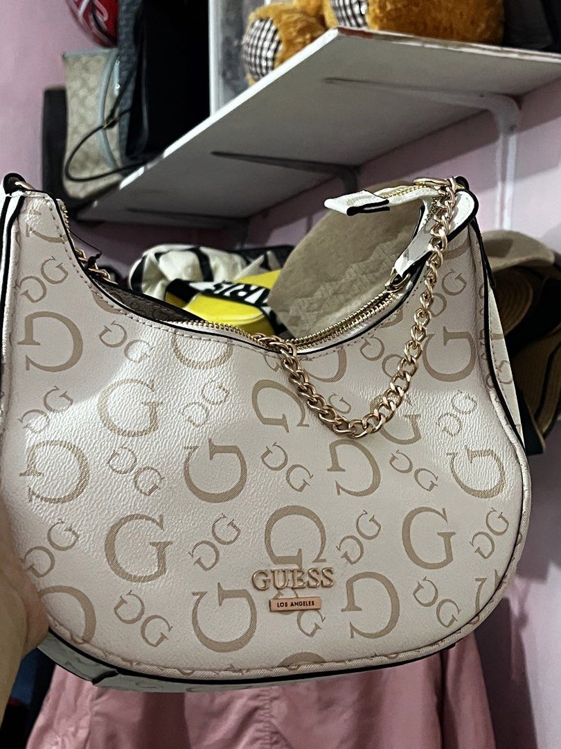 Guess Los Angeles Cream Monogram Shoulder Bag (Category: Shoulder Bags) located in Manila. Submitted by cleverstone_21f597 (Listing ID 1470583848, Image 2). Description: - Authentic Guess shoulder bag in a versatile cream color - Features an allover G monogram print with classy gold-tone hardware - Secure top zip closure and trendy decorative chain link accent - Includes an adjustable strap for a customized fit - Compact and lightweight design, p