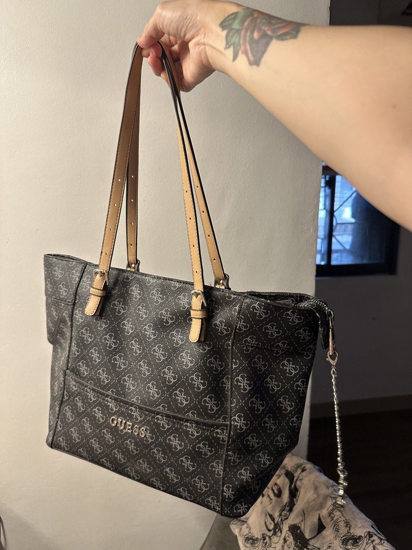 Guess Monogram Tote Bag with Charm (Category: Tote Bags) located in Manila. Submitted by anniesam (Listing ID 1470593832, Image 1). Description: - Brand: Guess authentic 100% - Design: Black and grey monogram pattern with tan adjustable straps - Hardware: Silver-tone with hanging Guess logo charm - Closure: Secure zip top - Interior: Clean beige branded fabric lining with zipped pocket and metal tag - Condition: Excellent, very clean inside and o