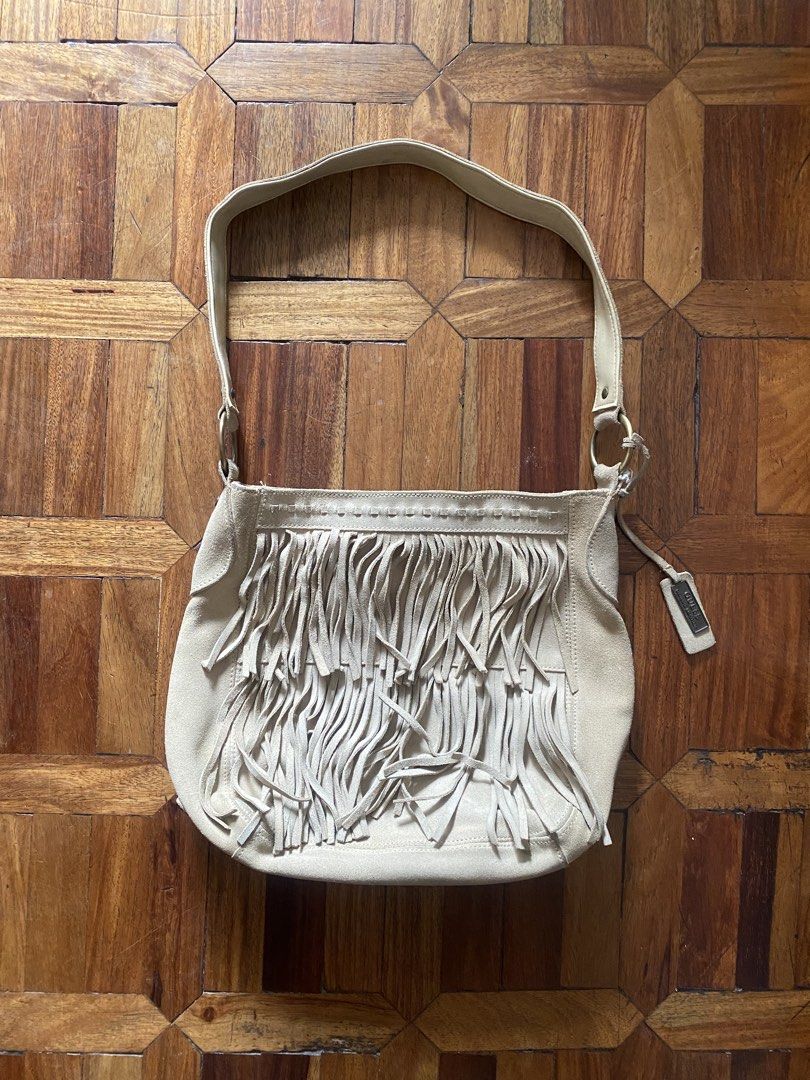 Guess Suede Fringe Shoulder Bag Beige (Category: Shoulder Bags) located in Manila. Submitted by anthony1723 (Listing ID 1470697176, Image 1). Description: - Brand: Guess - Material: Genuine leather suede - Color: Classic beige - Style: Boho-chic shoulder bag with trendy front fringe detailing - Closure: Secure magnetic snap - Interior: Branded fabric lining with a convenient zipper pocket - Hardware: Stylish brass-tone accents and custom Guess ha