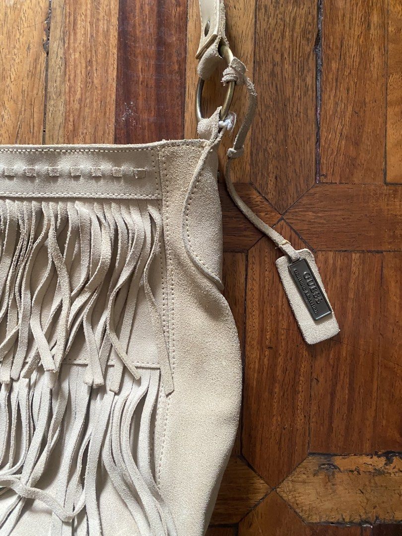 Guess Suede Fringe Shoulder Bag Beige (Category: Shoulder Bags) located in Manila. Submitted by anthony1723 (Listing ID 1470697176, Image 2). Description: - Brand: Guess - Material: Genuine leather suede - Color: Classic beige - Style: Boho-chic shoulder bag with trendy front fringe detailing - Closure: Secure magnetic snap - Interior: Branded fabric lining with a convenient zipper pocket - Hardware: Stylish brass-tone accents and custom Guess ha