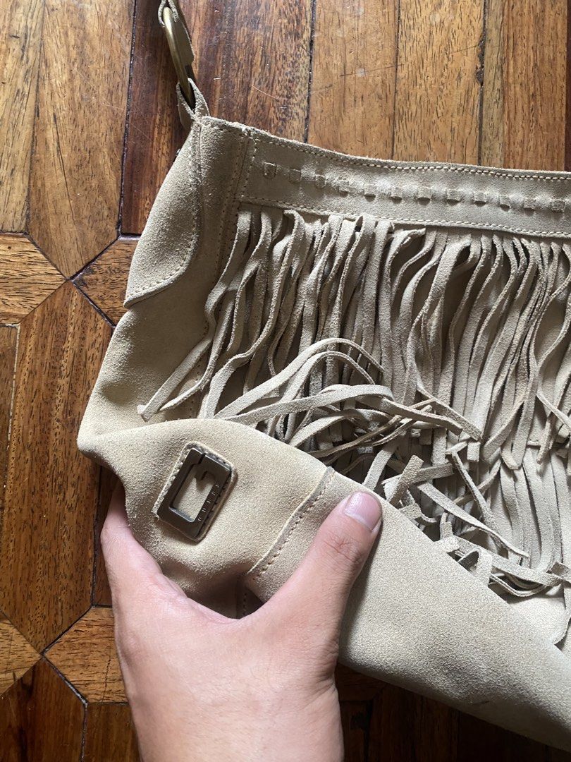 Guess Suede Fringe Shoulder Bag Beige (Category: Shoulder Bags) located in Manila. Submitted by anthony1723 (Listing ID 1470697176, Image 3). Description: - Brand: Guess - Material: Genuine leather suede - Color: Classic beige - Style: Boho-chic shoulder bag with trendy front fringe detailing - Closure: Secure magnetic snap - Interior: Branded fabric lining with a convenient zipper pocket - Hardware: Stylish brass-tone accents and custom Guess ha