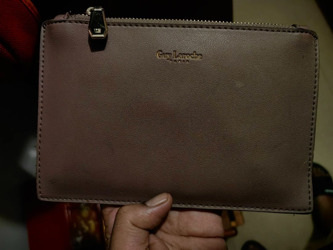Guy Laroche Pouch Clutch Wallet (Category: Purses & Pouches) located in Davao. Submitted by thefrugalshop (Listing ID 1470628295, Image 1). Description: - Authentic Guy Laroche pouch in a chic taupe/muted mauve shade - Subtle shimmer finish with elegant gold foil branding on the front - Secure top gold zipper closure with a custom metal pull tab - Slim, sleek profile designed to easily fit cards and cash - Clean, high-quality stitching along the 