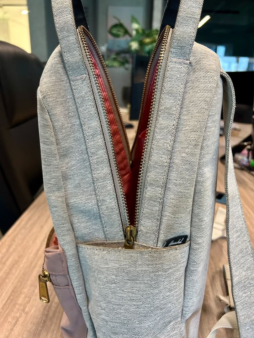 Herschel Grey and Pink Backpack (Category: Backpacks) located in Taguig. Submitted by thesleepypanda000 (Listing ID 1470580472, Image 3). Description: - Brand: Herschel (original) - Color: Heather grey with dusty pink front zip pocket - Features: Double top grab handles, adjustable shoulder straps, small front brand label - Condition: Clean interior and bottom base; no flaws but there are signs of usage and needs washing - Usage: Compact daily ba