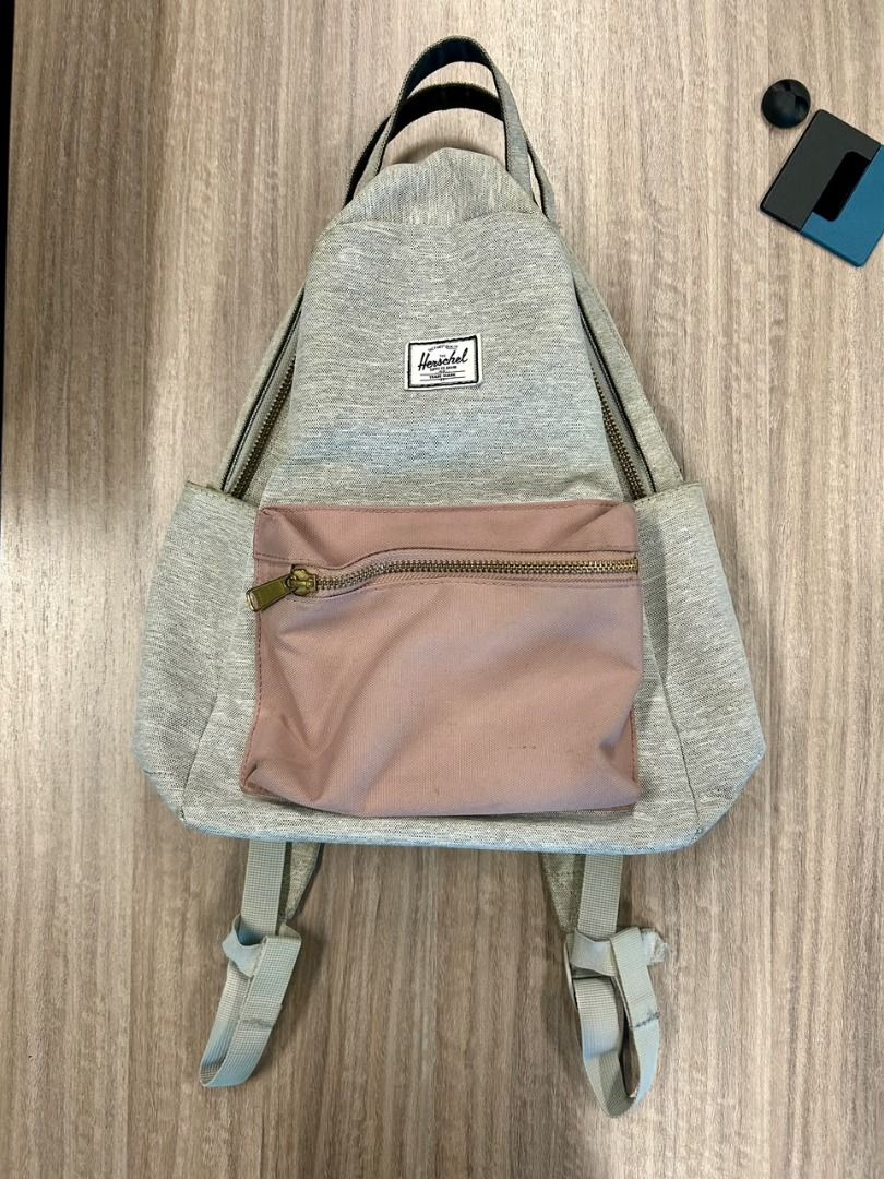 Herschel Grey and Pink Backpack (Category: Backpacks) located in Taguig. Submitted by thesleepypanda000 (Listing ID 1470580472, Image 1). Description: - Brand: Herschel (original) - Color: Heather grey with dusty pink front zip pocket - Features: Double top grab handles, adjustable shoulder straps, small front brand label - Condition: Clean interior and bottom base; no flaws but there are signs of usage and needs washing - Usage: Compact daily ba