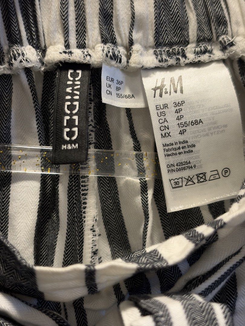 H&M Divided Striped Tie-Waist Pants (Category: Other Bottoms) located in Manila. Submitted by anjcuenca (Listing ID 1470696573, Image 3). Description: - Brand: H&M Divided - Pattern: Black and white vertical stripes - Size: EUR 36P / US 4P / CA 4P - Waistband: Elastic with a matching fabric tie belt - Material: Lightweight and comfortable - Origin: Made in India - Style: Versatile for casual wear or slight dress-up.