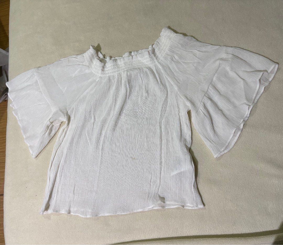 H&M White Off-Shoulder Bell Sleeve Blouse (Category: Blouses) located in Muntinlupa City. Submitted by sukimum (Listing ID 1470671569, Image 3). Description: BNWOT- never used, only washed. Very lightweight, slightly sheer crinkled fabric. Best fits M-XL frames. For S frames, better if you have wider shoulders. Has two faint brown stains on the sleeve and lower area (check latter photos). Not sure where it came from while it was stored, but i do 