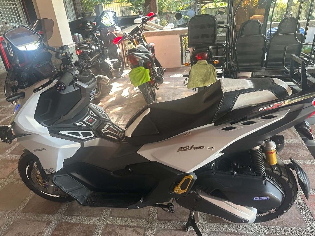 Honda ADV 160 Scooter with Upgrades (Category: Motorbikes for Sale) located in Taguig. Submitted by wisedeer.e43cf3 (Listing ID 1470653571, Image 2). Description: Honda ADV 160 scooter in white. Fitted with custom aftermarket upgrades including RCB brake calipers, upgraded disc rotors, titanium bolts, custom seat, and rear rack. Digital odometer reads 1,704 km. Clean condition, well maintained, ready for the road..