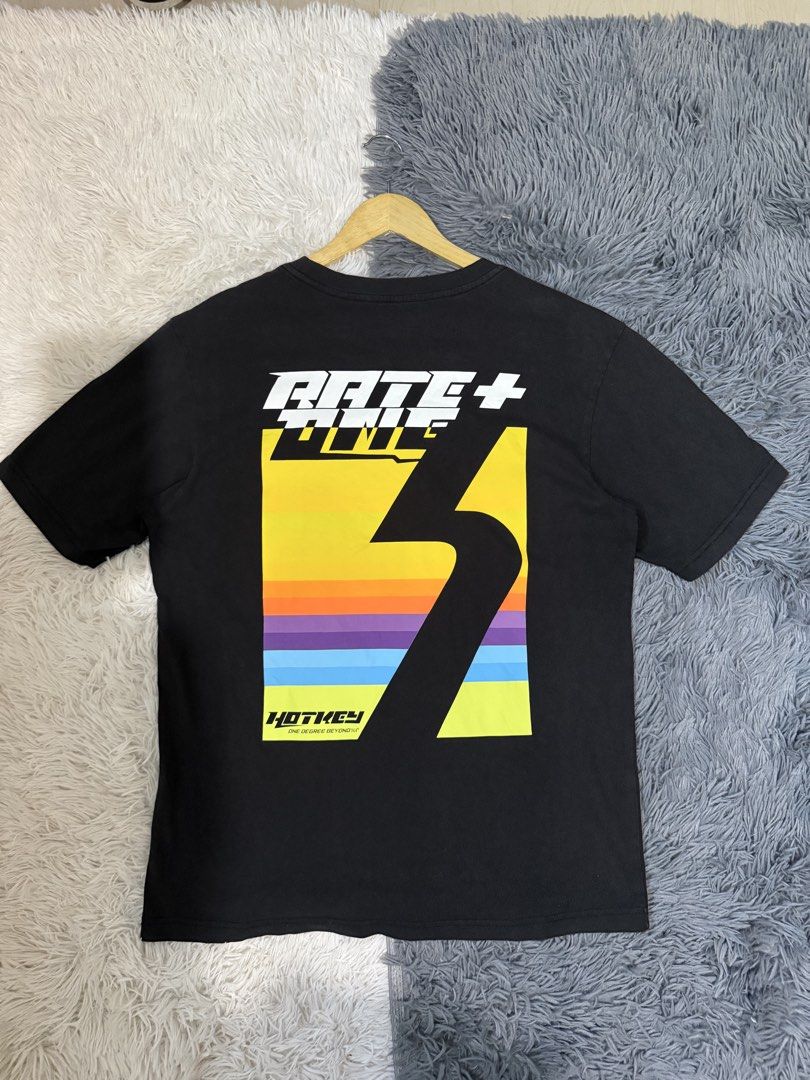 Hotkey Rate One Graphic Tee Black Size M (Category: Tshirts & Polo Shirts ) located in Manila. Submitted by keepercollection (Listing ID 1470588147, Image 1). Description: - Brand: Hot Key - Color: Black - Size: Small (Measures approx. 21 inches across the chest) - Design: Small embroidered circular rainbow patch on the left chest - Back Details: Large colorful graphic with 'Rate One' and 'One Degree Beyond' typography - Condition: Great pre-love