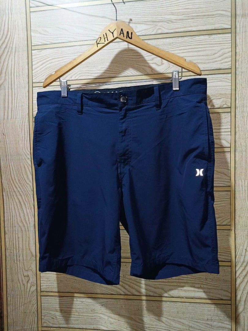 Hurley Men Navy Blue Shorts (Category: Shorts) located in Narra. Submitted by rhyanguan63087 (Listing ID 1470571279, Image 2). Description: - Brand: Hurley Size 36 - Color: Navy blue - Style: Classic fit with belt loops and button closure - Features: Small reflective logo on the leg, back pocket with button flap - Condition/Fabric: Clean fabric - Best for: Casual wear or outdoor activities.