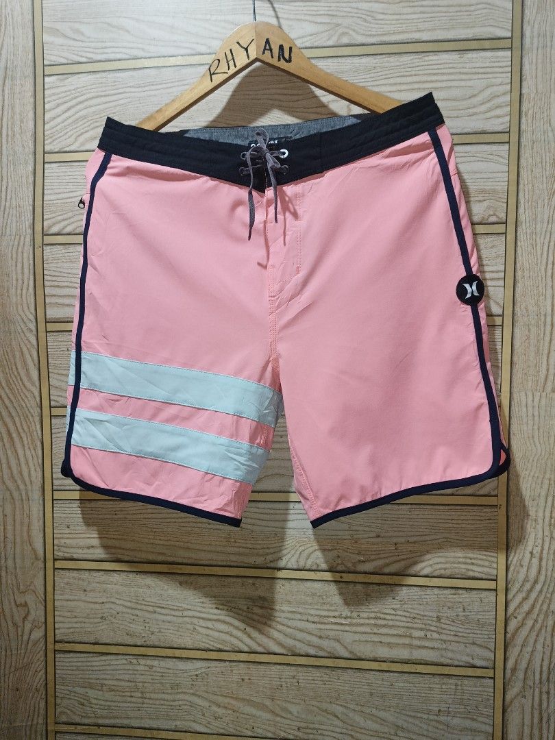 Hurley Phantom Boardshorts Pink Teal (Category: Swim Trunks & Board Shorts) located in Narra. Submitted by rhyanguan63087 (Listing ID 1470571536, Image 3). Description: - 30-31 Waistline Brand: Hurley Phantom - Color: Pink with teal horizontal stripes - Features: Black waistband with adjustable drawstring, secure back zip pocket with Hurley logo, and iconic logo on the left leg - Material: Lightweight, high-performance stretch fabric - Ideal for: