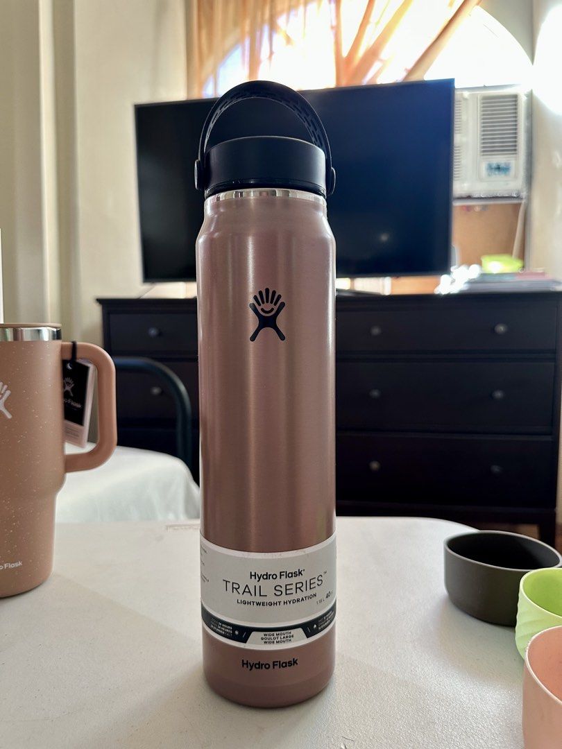 Hydro Flask Trail Series Lightweight Hydration 40oz Water Bottle (Category: Water Bottles & Tumblers) located in Quezon City. Submitted by MECasA (Listing ID 1470737266, Image 1). Description: - Brand: Hydro Flask Trail Series - Capacity: 40 oz with Wide Mouth opening - Color: Rose Gold metallic finish with black cap and branding - Condition: Brand new with paper label wrap intact - Features: Ultra-lightweight design for hiking and outdoor advent
