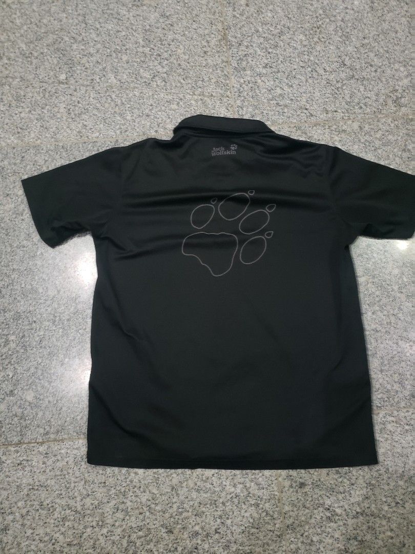 Jack Wolfskin Black Polo Shirt (Category: Tshirts & Polo Shirts ) located in Pagsanghan. Submitted by yuchinz (Listing ID 1470661661, Image 3). Description: - Brand: Jack Wolfskin - Color: Black - Material: 100% breathable polyester (easy to wash & maintain) - Design: Classic collar, 3-button placket, short sleeves - Details: Small logo on chest, large wolf paw outline graphic on the back - Condition: Excellent / Great for casual wear and outdoor