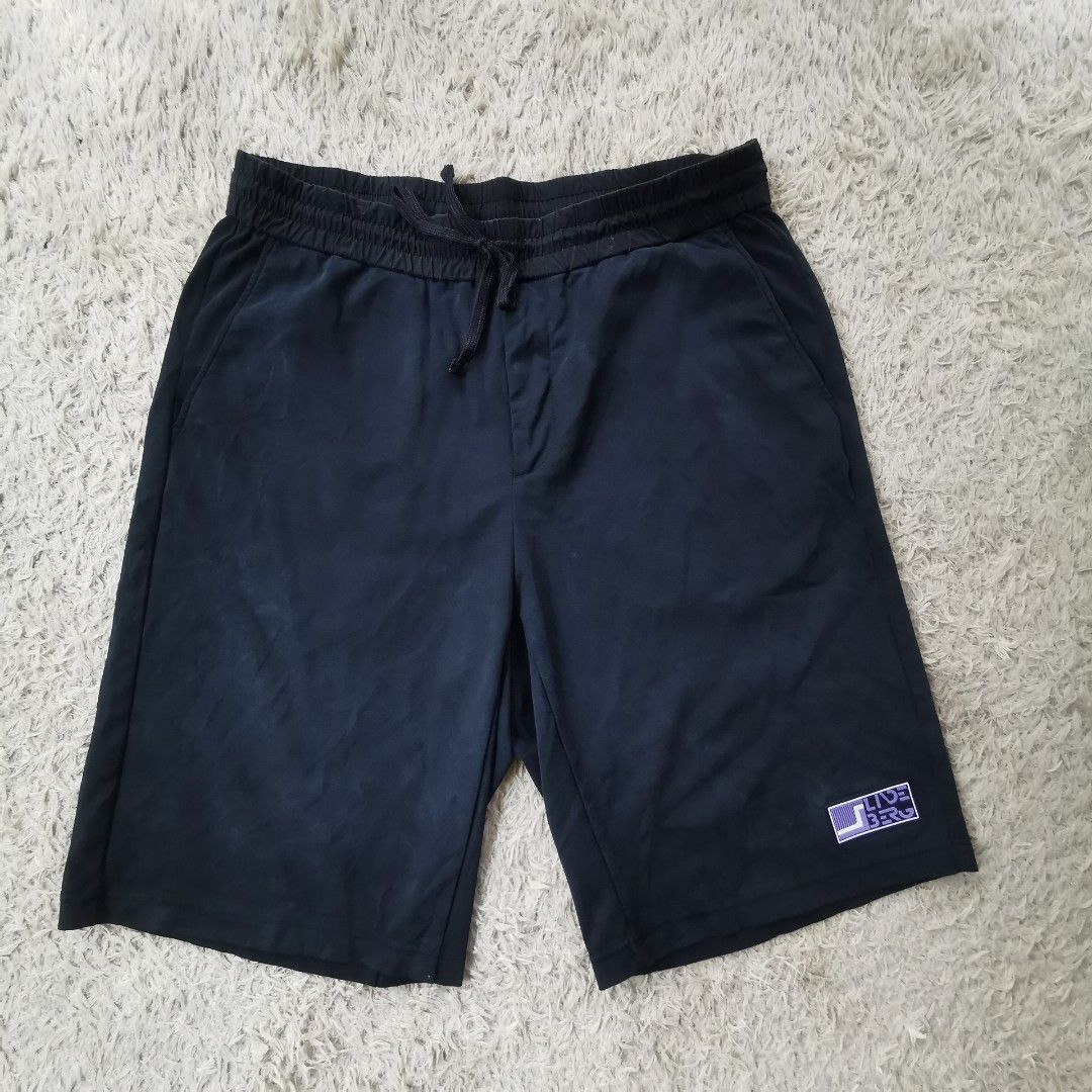 j.lindeberg Black Jersey Shorts with Drawstring Waist (Category: Shorts) located in Davao. Submitted by dmp1993 (Listing ID 1470622376, Image 1). Description: J.Lindeberg black shorts in jersey fabric. Elastic waistband with adjustable drawstring closure. Zippered back pocket featuring white text branding. Purple graphic patch attached near the lower hem. Clean dark finish overall, lightweight construction, suitable for training or casual wear..