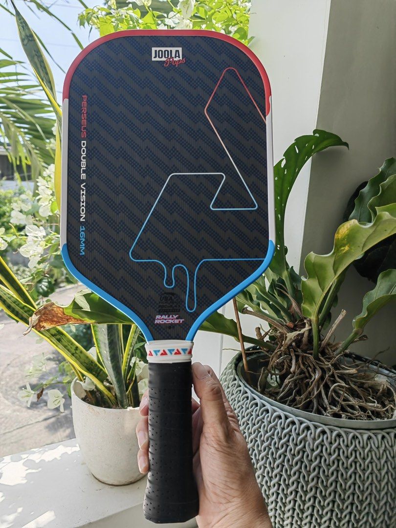 Joola Pops Perseus Double vision special edition (Category: Racket and Ball Sports) located in Cebu City. Submitted by citygirl829 (Listing ID 1470591823, Image 3). Description: - Model: JOOLA Pops Perseus Double Vision, special edition - Thickness: 16mm for maximum control - Design: Eye-catching red, white, and blue popsicle drip graphic - Surface: Textured carbon fiber for superior spin - Certification: Official USAPA approval stamp - Handle: C