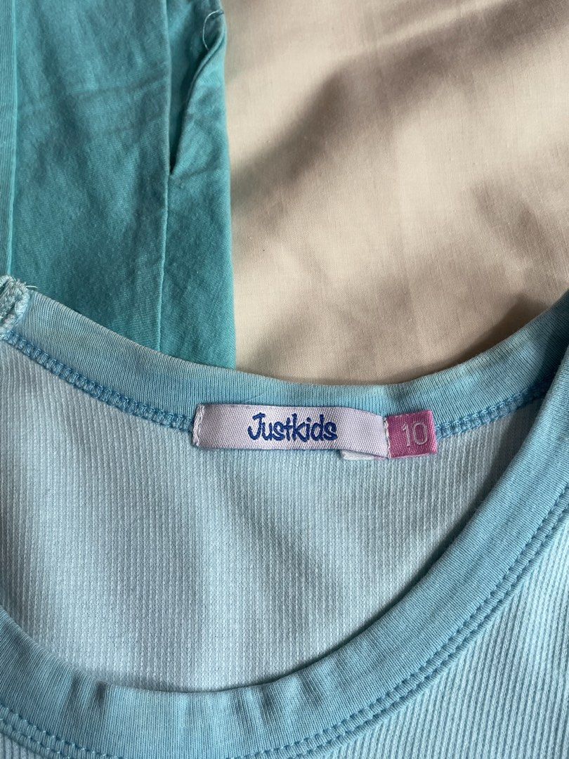 Just Kids Blue Tops Bundle Size 10 and 14 (Category: Babies & Kids Fashion) located in Iba. Submitted by wealtheallymari99 (Listing ID 1470714658, Image 2). Description: - Brand: Just Kids - Quantity: Bundle of 2 blue tops - Material: 100% Cotton, great for casual everyday wear - Item 1: Light blue ribbed tank top (Size 10) - Item 2: Turquoise tee with 'Believe in Yourself' graphic (Size 14) - Condition: Excellent/Pre-loved.