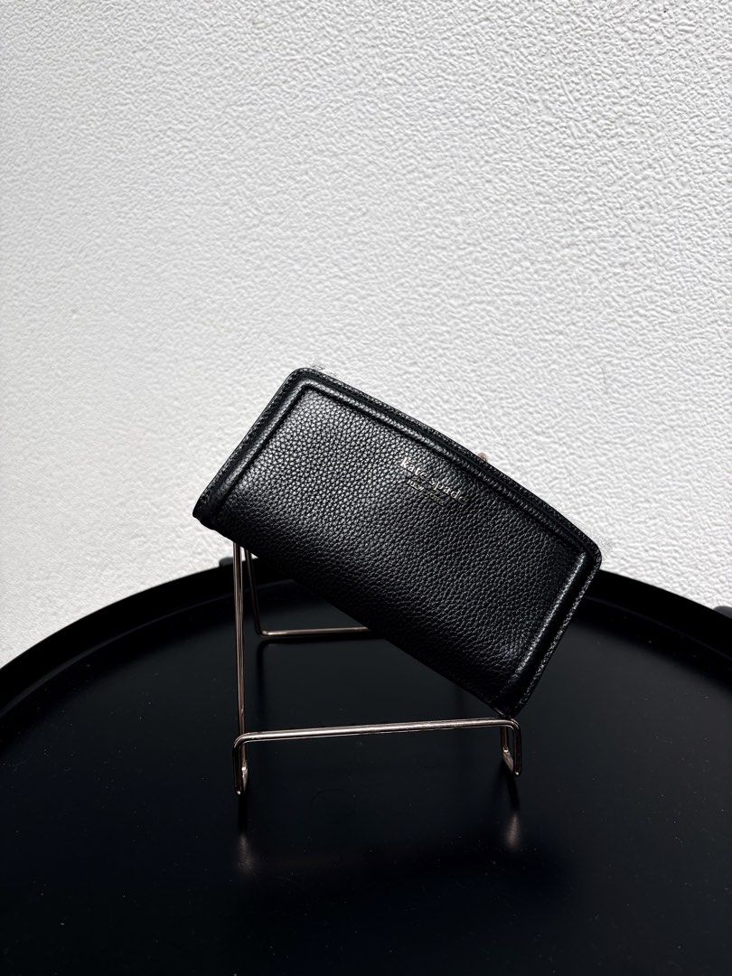 Kate Spade New York black leather wallet (Category: Wallets & Card holders) located in Quezon City. Submitted by new.cuteshop (Listing ID 1470663317, Image 1). Description: - Brand: Kate Spade - Material: Premium black pebbled leather - Hardware: Silver stamped lettering with protective wrapping still attached - Closure: Secure zip-around design - Fit: Compact and easy to slip into any daily bag - Condition: Pristine with clean stitching througho