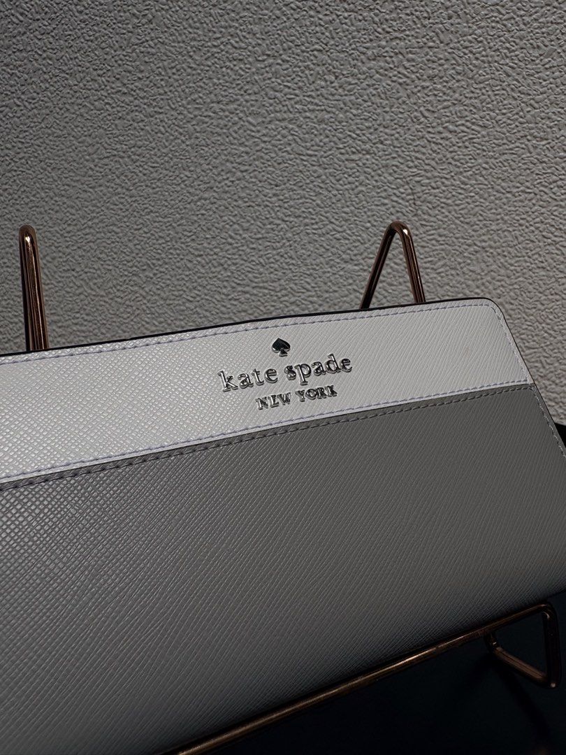 Kate Spade New York Two-Tone Wallet (Category: Wallets & Card holders) located in Quezon City. Submitted by new.cuteshop (Listing ID 1470663065, Image 3). Description: - Authentic Kate Spade New York long wallet - Color: White and grey - Material: Durable, scratch-resistant Saffiano leather - Hardware: Silver-tone front lettering - Exterior: Handy zip pocket on the back for coins - Closure: Secure snap closure - Interior: Clean and well-organized