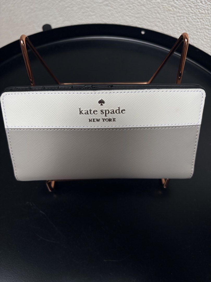 Kate Spade New York Two-Tone Wallet (Category: Wallets & Card holders) located in Quezon City. Submitted by new.cuteshop (Listing ID 1470663065, Image 1). Description: - Authentic Kate Spade New York long wallet - Color: White and grey - Material: Durable, scratch-resistant Saffiano leather - Hardware: Silver-tone front lettering - Exterior: Handy zip pocket on the back for coins - Closure: Secure snap closure - Interior: Clean and well-organized