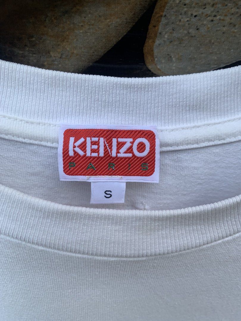 Kenzo x Nigo pocket tee. (Category: Shirts) located in Aloran. Submitted by chester78864 (Listing ID 1470668811, Image 3). Description: - Brand: Kenzo Paris - Color: White - Material: 100% Cotton - Size: Small (US S / CN 170/90A) - Fit: Regular fit, short sleeves, crew neck - Details: Left chest pocket with embroidered floral logo, red brand tag inside collar - Origin: Made in Portugal - Condition: Excellent, clean with no stains or damage.