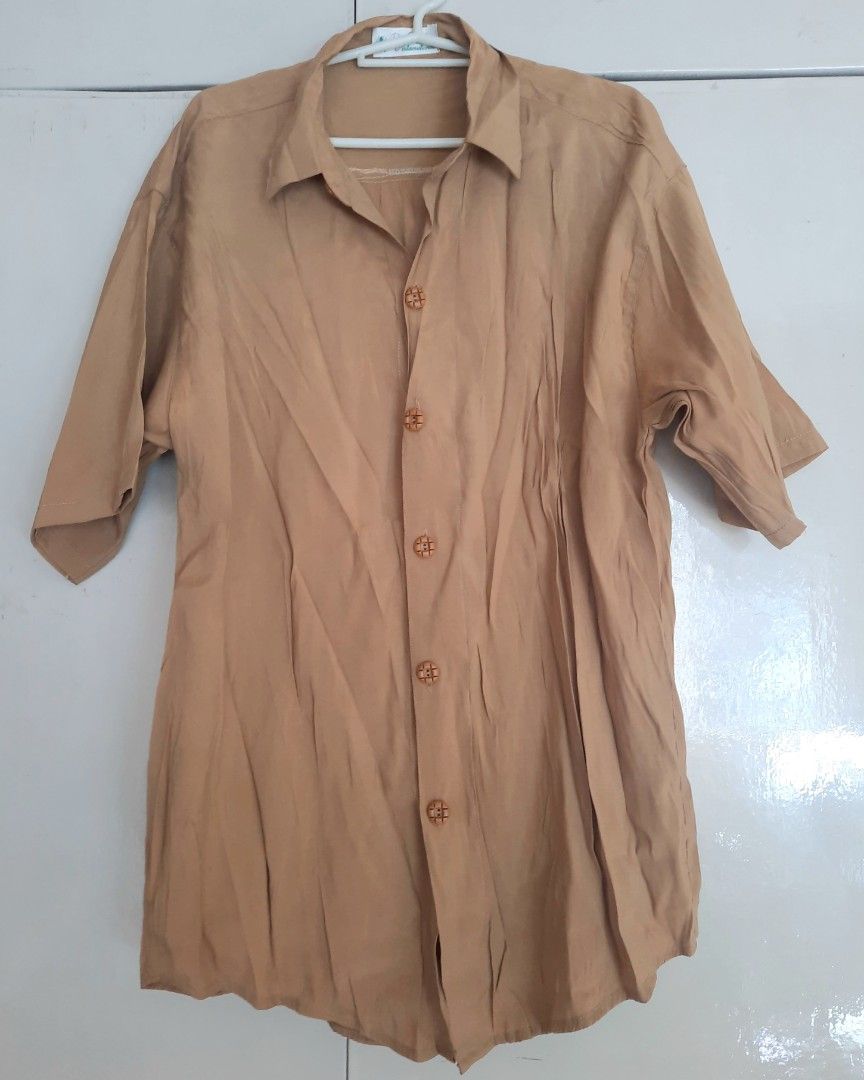 Khaki Oversized Short-Sleeve Button-Down Collared Tunic Blouse (Category: Blouses) located in Quezon City. Submitted by dannikkishoppe2 (Listing ID 1470689846, Image 2). Description: Khaki Oversized Short-Sleeve Button-Down Collared Tunic Blouse ‼️₱180‼️ Embrace relaxed, effortless style with this neutral beige button-down shirt. Featuring a classic pointed collar, short wide sleeves, and unique decorative textured buttons down the front. Crafted