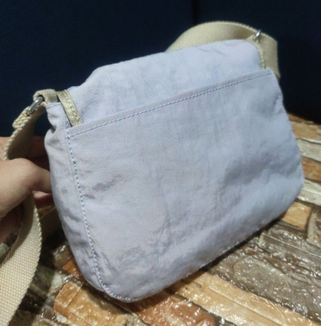 Kipling Crossbody Bag Light Purple with Monkey Keychain (Category: Cross-body Bags) located in Villasis. Submitted by jinkyreyann (Listing ID 1470617337, Image 2). Description: - Brand: Kipling Crossbody Bag - Color: Light purple with beige adjustable strap and mint green interior lining - Exterior: Front flap closure and convenient back slip pocket - Interior: Spacious main compartment with an extra zipper pocket - Inclusions: Comes with the ico
