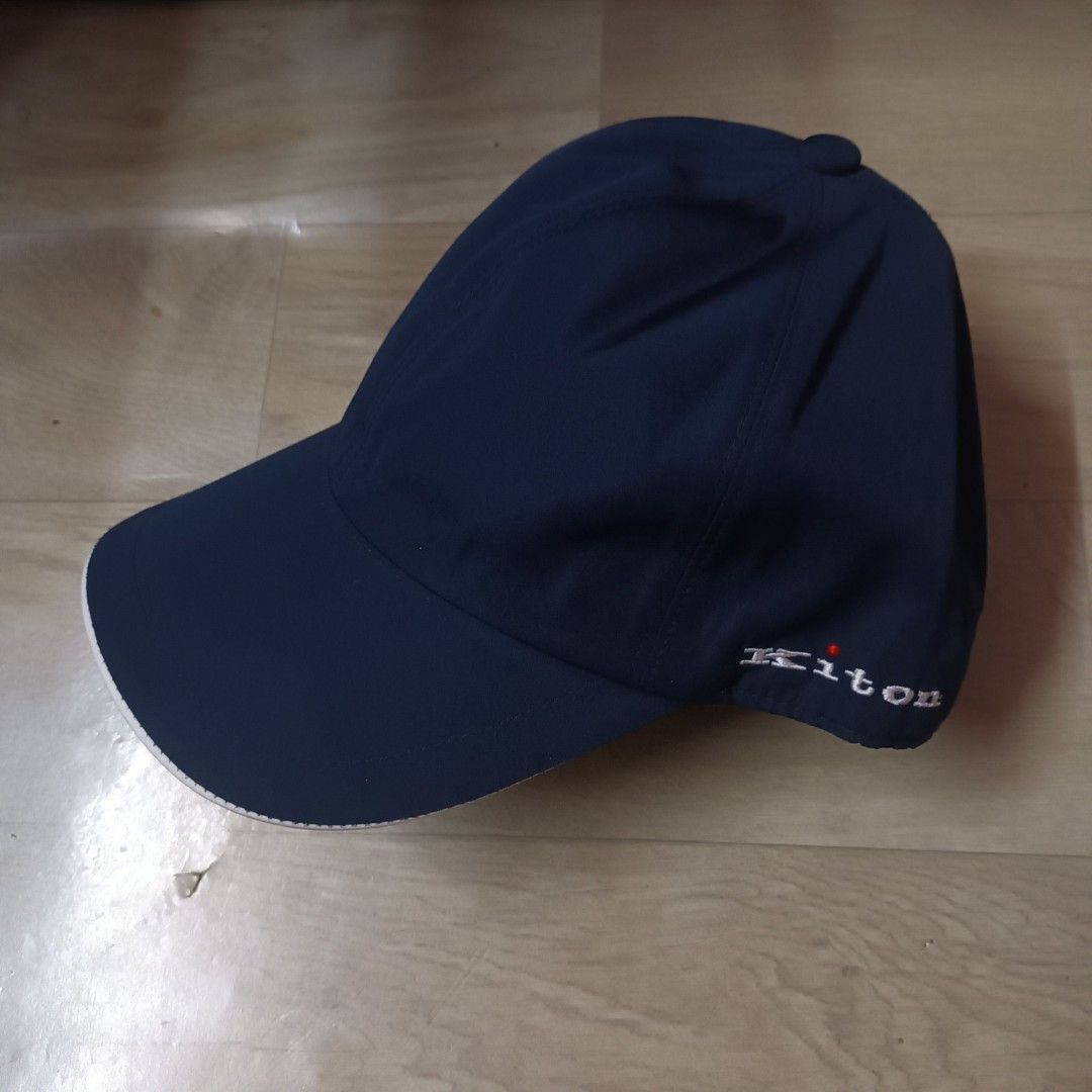 Kiton Napoli Navy Blue Cap (Category: Caps & Hats) located in Manila. Submitted by itsnik444 (Listing ID 1470636978, Image 1). Description: - Brand: Kiton Napoli - Color: Dark navy blue - Design: Classic curved brim with embroidered side logo and red dot accent - Interior: Grey lining with official brand tags - Fit: Adjustable strap at the back for a custom fit - Condition: Clean finish, ready to wear.