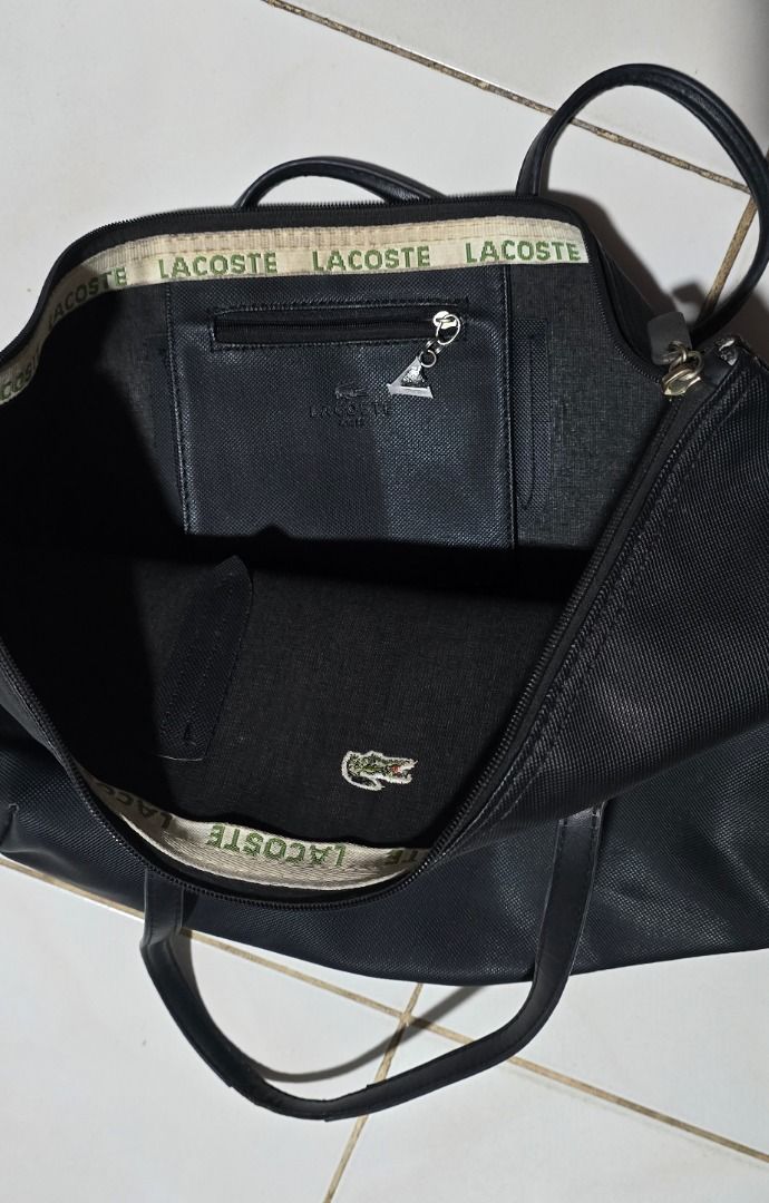 Lacoste Black Tote Bag - Negotiable!!! (Category: Tote Bags) located in Manila. Submitted by axelyuna.27 (Listing ID 1470584928, Image 3). Description: Authentic black Lacoste tote bag featuring comfortable double shoulder straps and a spacious interior with a zippered pocket. Showcases the iconic green crocodile logo on the front and inside base. Please note that the handle edges show heavy peeling and wear, but the bag is still highly functiona