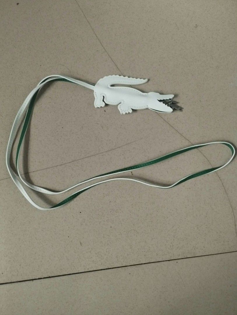 Lacoste White Crocodile Bag Charm Strap (Category: Cross-body Bags) located in Manila. Submitted by drewzioncl00303 (Listing ID 1470668565, Image 1). Description: - Color: White leather with a green underside finish - Design: Unique crocodile charm with metal clip details inside the jaws - Strap: Comes with a standard long strap attached - Use: Great accessory for handbags, totes, and purses - Condition: Brand new and ready to style.