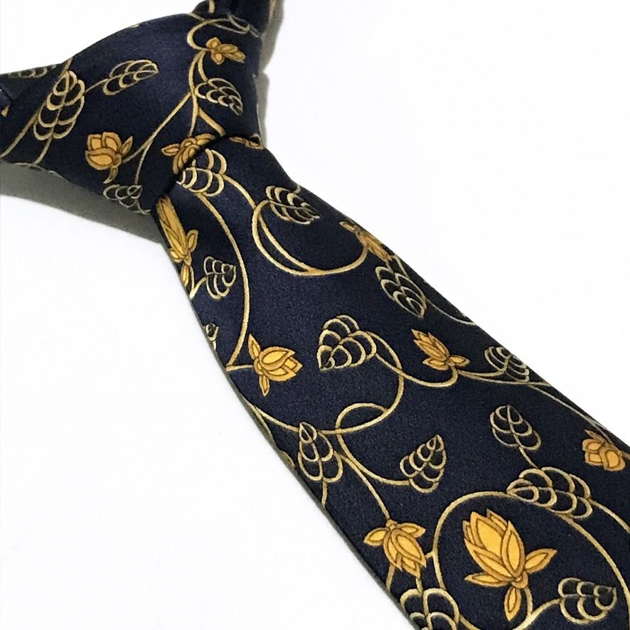 Lanvin Deep Navy Floral Neck Tie (Category: Ties) located in Taguig. Submitted by retrogaze (Listing ID 1470713190, Image 1). Description: This luxury 100% silk necktie by Lanvin features a smooth, deep navy blue satin base adorned with an intricate Art Nouveau-inspired botanical print. The design showcases sinuous golden vines, delicate leaf tendrils, and stylized lotus blossoms in rich golden-yellow hues flowing gracefully across the length of 