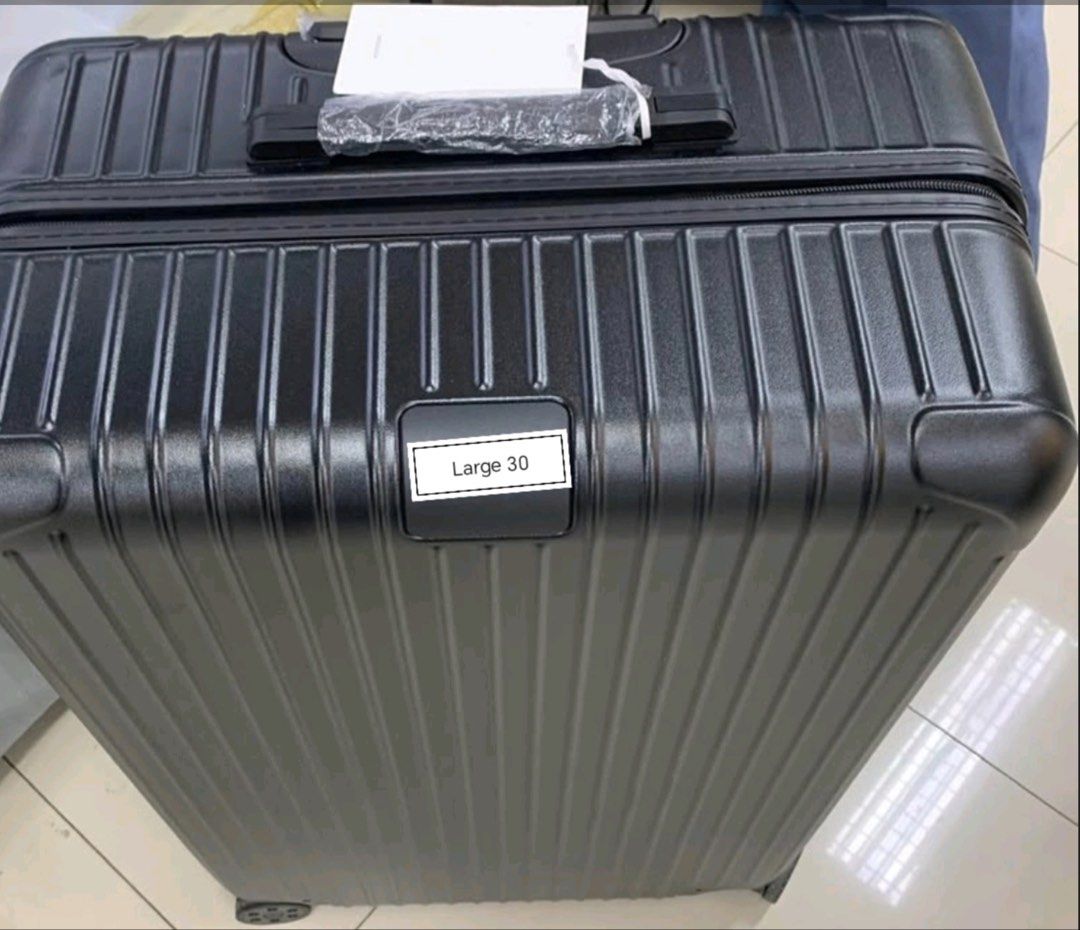 Large 30 Luggage (Category: Luggage) located in Manila. Submitted by dh3nz1 (Listing ID 1470741958, Image 1). Description: - Size: Large 30-inch suitcase - Color/Design: Solid black with a modern vertical ribbed texture - Material: Sturdy hard shell construction - Condition: Brand new with swing tag attached; top handle and wheels still wrapped in original protective plastic - Capacity: Generous interior space, ideal for long vacations and extend