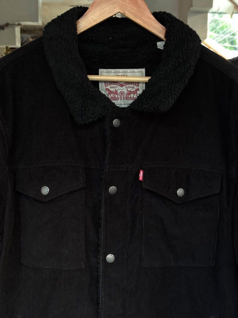 Levi's Black Corduroy Sherpa Jacket (Category: Coats, Jackets and Outerwear) located in Mati. Submitted by abu_razmey (Listing ID 1470728427, Image 2). Description: - Brand: Levi's - Material: Black corduroy with thick sherpa lining and collar - Closure: Front metal buttons plus zipper - Pockets: Two buttoned chest flap pockets and lower side pockets - Details: Iconic red Levi's tab and branded metal hardware - Fit/Use: Warm winter layer, stylish