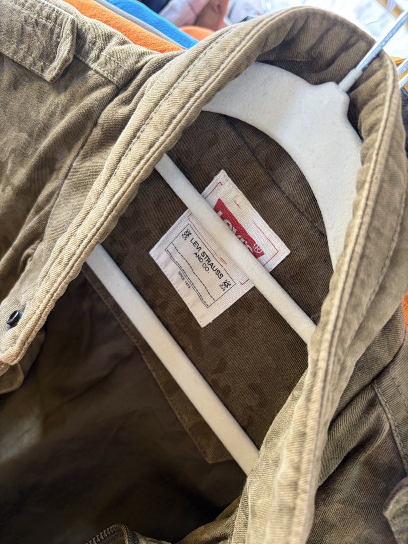 Levi's Olive Camo Zip-Up Utility Vest (Category: Vests) located in Kalibo. Submitted by shi1234xs (Listing ID 1470619869, Image 2). Description: FOR HOOK UP FREESHIP - Brand/Model: Authentic Levi's Olive Green Camouflage Utility Vest - Size: Height 135cm (Lot No. LO5JJP50) - Closure: Full zip with secure snap buttons - Pockets: Multiple functional front pockets - Details: Embroidered yellow Levi's logo on the chest - Material: Durable cotton blen