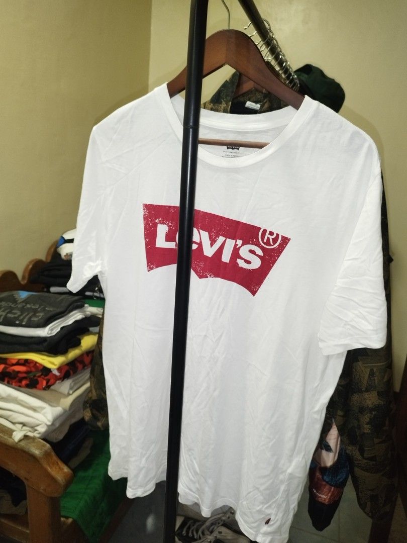 Levi's White Graphic Tee Size L (Category: Tshirts & Polo Shirts ) located in Tuguegarao City. Submitted by ZeevLim (Listing ID 1470610226, Image 1). Description: - Brand: Levi's - Color: White with distressed red batwing logo - Size: L (Made in Turkey) 21w 29l - Design: Short sleeves, crew neck, and classic red tab on the hem.
