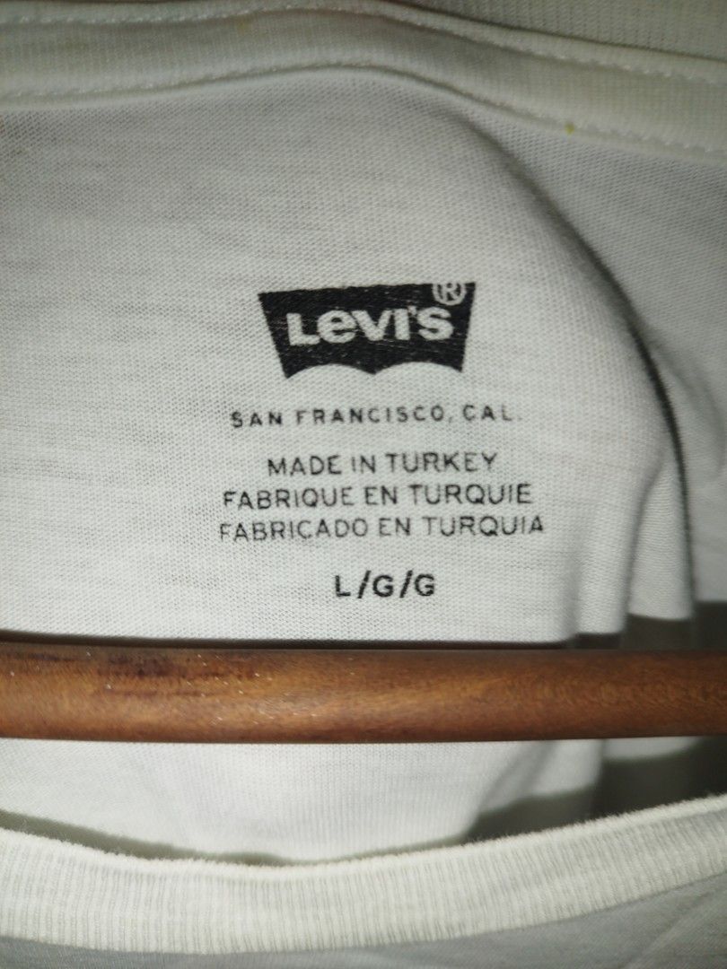 Levi's White Graphic Tee Size L (Category: Tshirts & Polo Shirts ) located in Tuguegarao City. Submitted by ZeevLim (Listing ID 1470610226, Image 3). Description: - Brand: Levi's - Color: White with distressed red batwing logo - Size: L (Made in Turkey) 21w 29l - Design: Short sleeves, crew neck, and classic red tab on the hem.