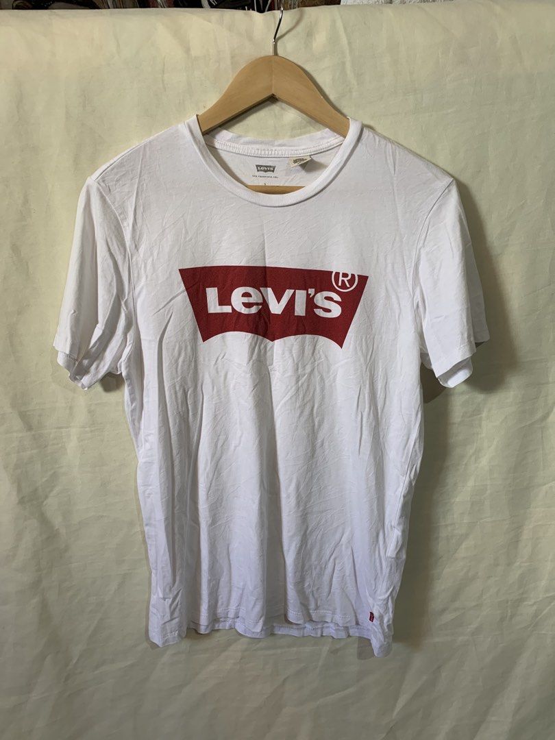 Levi's White Graphic T-Shirt (Category: Shirts) located in Davao. Submitted by cheineebau09680 (Listing ID 1470607455, Image 1). Description: - Brand: Levi's - Color: White with iconic red batwing logo - Size: Small (Standard fit) - Material: 100% Cotton - Details: Crew neckline, short sleeves, includes original inside care tags - Origin: Made in Sri Lanka - Condition: Brand new / Excellent pre-loved.