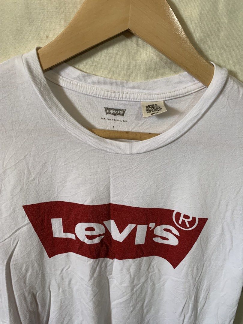 Levi's White Graphic T-Shirt (Category: Shirts) located in Davao. Submitted by cheineebau09680 (Listing ID 1470607455, Image 2). Description: - Brand: Levi's - Color: White with iconic red batwing logo - Size: Small (Standard fit) - Material: 100% Cotton - Details: Crew neckline, short sleeves, includes original inside care tags - Origin: Made in Sri Lanka - Condition: Brand new / Excellent pre-loved.