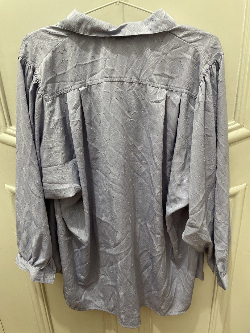 Light purple textured button-down shirt with lapel collar (Category: Blouses) located in Cainta. Submitted by nancygoreng (Listing ID 1470621319, Image 2). Description: - Color: Light purple with a subtle tonal jacquard pattern - Fit: Relaxed, loose fit with drop shoulders - Details: Lapel collar, front button closure, and pleated back yoke - Fabric: Soft material with a gentle sheen - Styling: Versatile piece great for layering or wearing on its