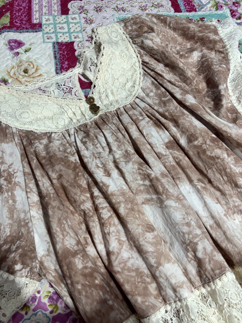 Liz Lisa Brown Batwing Top (Category: Blouses) located in Sual. Submitted by cinnamorol_lovar (Listing ID 1470624105, Image 3). Description: - Brand: Liz Lisa (Authentic Japanese Gyaru brand) - Color/Print: Brown tie-dye with cream lace details - Features: Lace collar, cuffs, and hem, pleated bodice, keyhole neckline with gem buttons - Sleeves: Short flared sleeves - Fit: Loose and flowy - Material: Soft and lightweight fabric.