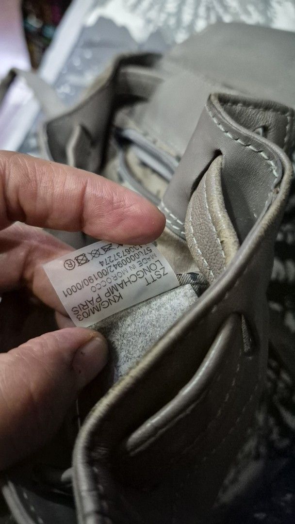 Longchamp Le Pliage Cuir Leather Backpack Grey (Category: Looking For) located in Baguio. Submitted by jhaz_bags (Listing ID 1470679641, Image 3). Description: - Brand: Longchamp - Material: Soft grey leather (Made in Morocco) - Closure: Flap top with snap button and drawstring - Straps: Adjustable leather straps with a top grab handle - Size: Compact, ideal for daily essentials - Condition: Pre-loved with visible wear on the front flap and edges