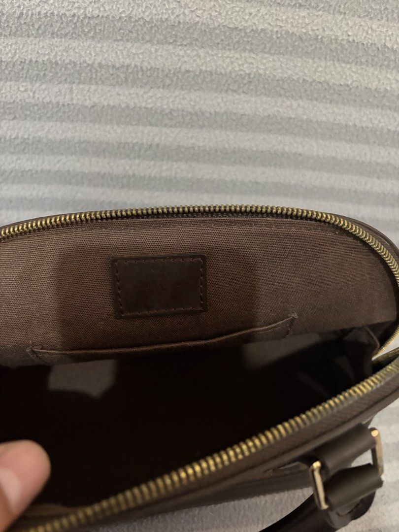 Louis Vuitton Damier Ebene Alma Handbag (Category: Luxury Bags & Wallets) located in Pasig City. Submitted by mau_llamas (Listing ID 1470692373, Image 2). Description: - brown checked coated canvas with dark brown smooth leather trim - Elegant gold-tone hardware and structured dome shape - Dual rolled leather handles for comfortable hand carry - Secure top zip closure to keep your belongings safe - Brown fabric-lined interior complete with a hand
