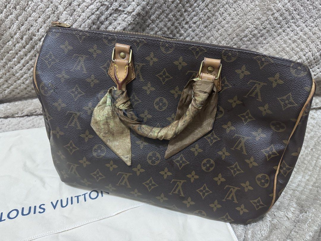 Louis Vuitton Monogram Canvas Handbag 35 (Category: Luxury Bags & Wallets) located in Quezon City. Submitted by itsnotmeitsu (Listing ID 1470616250, Image 1). Description: - Authentic Louis Vuitton monogram canvas handbag - Clean canvas body with natural leather patina on vachetta trim and handles - Features handles wrapped in a chic patterned silk twilly scarf - Includes matching padlock with keys and original dust bag, LegitGrails - Ships secur
